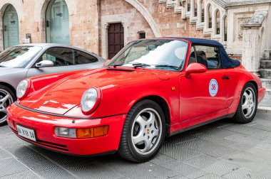 Porsche sahipleri ve koleksiyoncular mitinginde Foligno 'nun tarihi merkezine park etmiş kırmızı bir Porsche 911 Carrera Cabriolet nesli 993 klasik bir stil sergiliyor. Foligno, İtalya, 18 Mayıs 2025.