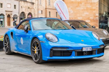 Porsche sahipleri ve koleksiyoncular mitinginde Foligno 'nun tarihi merkezine park etmiş mavi bir Porsche 911 Carrera Cabriolet 992 lüks ve tarz sergiliyor. Foligno, İtalya, 18 Mayıs 2025