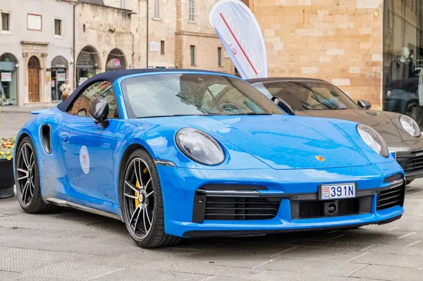 Porsche sahipleri ve koleksiyoncular mitinginde Foligno 'nun tarihi merkezine park etmiş mavi bir Porsche 911 Carrera Cabriolet 992 lüks ve tarz sergiliyor. Foligno, İtalya, 18 Mayıs 2025