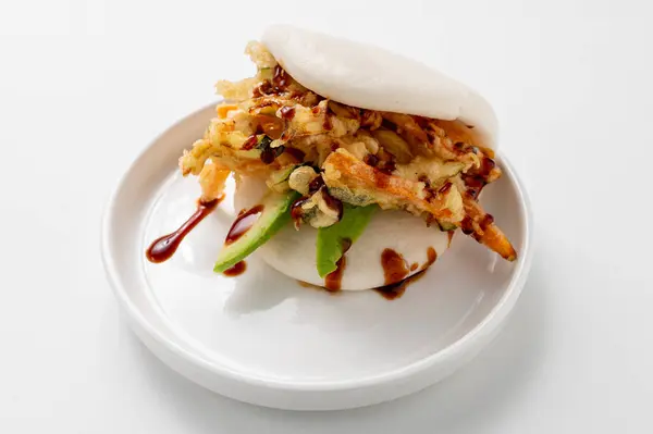 Tempura sebzeli ve avokadolu bir tepsi vegan Bao, beyaz arka planda servis ediliyor. Canlı, bitkisel bir Asya yemeği. Çin ve Japon mutfağı, temiz ve asgari estetik.