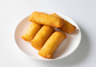 Erimiş peynir ve ekmek kırıntılarıyla yapılan kızarmış peynirli kroketler beyaz arka planda izole edilmiş. Doğal ışık bu popüler abur cuburu ön plana çıkarıyor, fast food ve sokak yemekleri aşıkları için mükemmel..