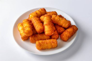 Beyaz bir zemin üzerinde patates kroketleri izole edilmiş patates püresi ve ekmek kırıntılarından yapılmış. Doğal ışık, fast food ve sokak yemekleri aşıkları için ideal olan bu popüler abur cuburu geliştirir..