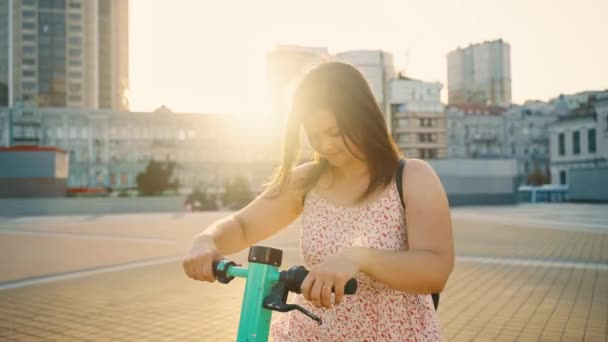 在阳光明媚的夏日 骑电动车的小女孩很可爱 城市电气交通 摩托车的租金 生态交通方式 放松点 高质量的4K镜头 — 图库视频影像