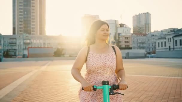 Uma Menina Monta Uma Scooter Elétrica Pelas Ruas Uma Cidade — Vídeo de Stock