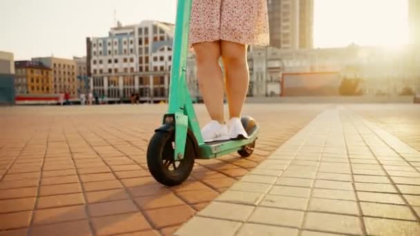 少女は押しのけて街中の電動スクーターに乗り始める 生態輸送 高品質4K映像 — ストック動画