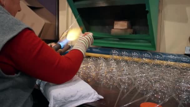 一名女工用燃烧器加热玻璃杯 把圣诞玻璃玩具吹灭了 玻璃新年玩具的制造 玻璃鼓风机 高质量的4K镜头 — 图库视频影像