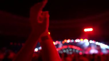 Konserde dans eden bir kızın elleri dans hayranlarının ve sahnenin arka planında değildir. Konser kalabalığının siluetleri. Konserdeki mutlu insanlar. Yüksek kalite 4K görüntü.