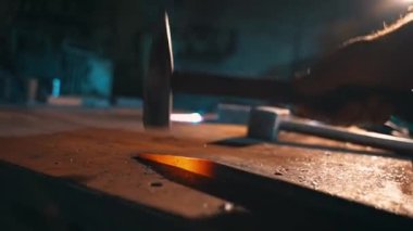 Demirci dükkanında çekiçle örsün üzerindeki kızgın metal parçayı şekillendirmek. Kapatın. Metal dövmesi. Yüksek kalite 4k görüntü