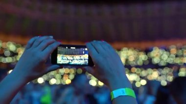 Kalabalık dans ediyor, konserde ellerini kaldırıyor. Parlak renkli sahne ışıklandırması. Eğlence. Sahne ışıkları. Konserdeki mutlu insanlar. Yüksek kalite 4k görüntü