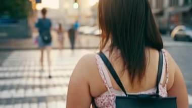 Şehirde yaya geçidi boyunca sırtında sırt çantası olan genç bir kızın arka görüntüsü. Yol kurallarına uymak için. Yüksek kalite 4k görüntü