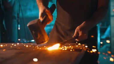 Demirci bir elinde iş parçasını tutar, diğer elinde de ürünü ürettiği çekiç. Yüksek kalite 4k görüntü