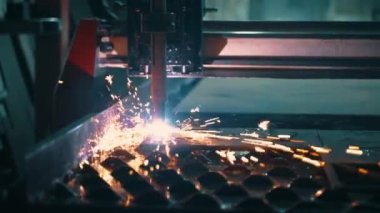 Modern bir CNC fiber lazer makinesi metal levha üzerindeki desenleri keser. Kesme işlemi sırasında lazer ışınından parlak kıvılcımlar uçuşuyor. Yüksek kalite 4k görüntü