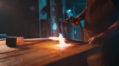 Bir üretim işçisinin atölyesinde metalin yakın çekim oksijeni ısıtılıyor. Çalışan bir oksikodon yakıtı ocağı yakın çekim ısıtır. Yüksek kalite 4k görüntü