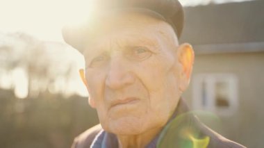 Sokakta duran şapkalı yaşlı bir adamın portresi. Kameraya yakından bakan buruşuk yaşlı bir yüz. Yalnızlığın üzüntüsü. Yaşlı bir adam, baba. Büyükbabaların portresi.