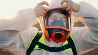 Dışarıda koruyucu solunum cihazına bağlı biri koruyucu bir kimyasal giysi giyer. Radyoaktif bölgede solunum cihazında ekolojist. Kimyasal saldırı. Yüksek kalite 4k görüntü