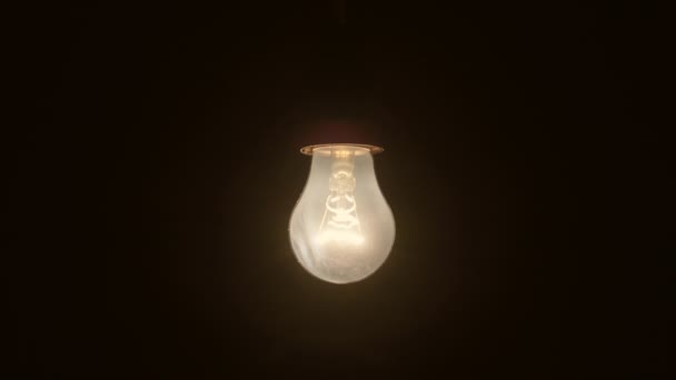 古いレトロなヴィンテージの白熱電球のクローズアップ電球がオンとオフを切り替えます ランプのフィラメントが表示されます 明るい電球で空間の照明 — ストック動画