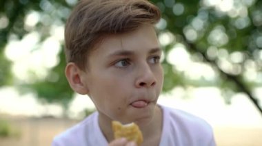 Yakışıklı beyaz bir çocuğun nugget yediği yakın plan çekimler. İnsan sağlıksız yiyecekler yer. Sağlıksız yiyeceklerin tadını çıkarıyorum. Sağlıksız yiyecekler. Modern hayat. Ön manzara. Yüksek kalite 4k görüntü