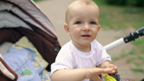 Yakışıklı Çocuk Elinde Sarı Bir Arabayla Bebek Arabasında Oturur Kameraya — Stok video