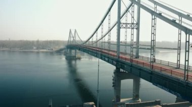 UKRAINE, KYIV, - JULY 16, 2020: Side view from a birds eye view of the Park Pedestrian Bridge in Kyiv.Ukraine. Pedestrian bridge across the Dnieper river.Drone video footage.High quality 4k footage