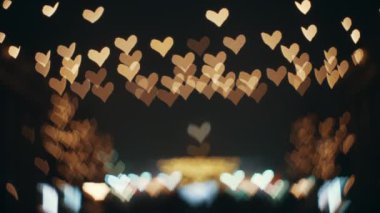 Bokeh with defocused abstract glowing golden hearts. Festive background for text. Magic romantic abstract background. Beautiful light abstract bokeh effect. High quality 4k footage