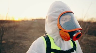 Beyaz koruyucu takım elbiseli, solunum cihazlı, sokaktaki kameraya bakan bir doktorun yakın plan portresi. Koronavirüsün yayılma tehdidi. Covid-19 salgını. Yüksek kalite 4k görüntü