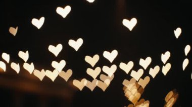 Heart defocused abstract glowing bokeh in golden. Magical romantic abstract background. Beautiful bokeh light abstract effect.Valentines day Love or romance background.High quality 4k footage