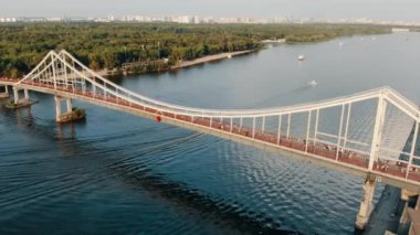 UKRAINE, KYIV, - JULY 16, 2020: Side view from a birds eye view of the Park Pedestrian Bridge in Kyiv.Ukraine. Pedestrian bridge across the Dnieper river.Drone video footage.High quality 4k footage