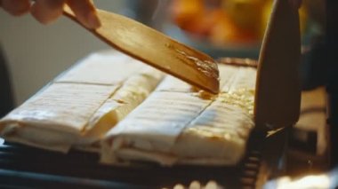Hazır ev yapımı Pita ekmeği shawarma yakın plan, yan manzara. Tabak, spatula yardımıyla bir tabağa konur. Shawarma elektrikli ızgaraya yakın çekim yapıyor. Yüksek kalite 4k görüntü