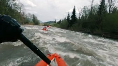 Rafting yapan bir adam baharda bir dağ nehrinde akıntıya karşı yüzer. Onun alanında bir profesyonel. Aşırı profesyonel su sporu. Boş zaman. Yüksek kalite 4k görüntü