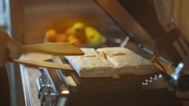 Aşçı ızgarayı açar ve doldurulmuş pideleri ahşap spatulalarla çevirir. Lavaş, sebze ve tavuk. Elektrikli ızgarada pişiyor. Kebap, shawarma. Yüksek kalite 4k görüntü