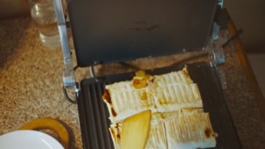 Hazır ev yapımı Pita ekmeği shawarma yakın plan, yan manzara. Tabak, spatula yardımıyla bir tabağa konur. Shawarma elektrikli ızgaraya yakın çekim yapıyor. Yüksek kalite 4k görüntü