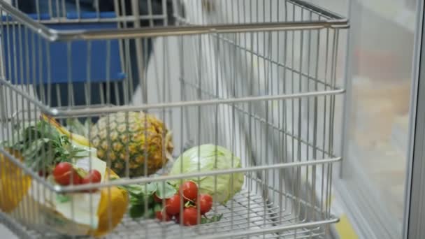 Vásárló Megtölti Kosarát Gyümölcsökkel Zöldségekkel Egyéb Termékekkel Szupermarketben Bevásárlókocsi Élelmiszerrel — Stock videók