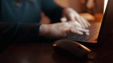 Evde sarı ışıkta dizüstü bilgisayarla çalışan kadınların yakın çekimi. Akşamları ödev yapıyorum. Serbest bir iş. Yüksek kalite 4k görüntü