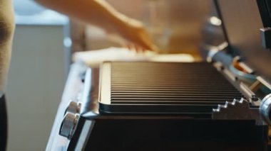 Evdeki mutfak masasında ısıtmalı ızgara açan bir kadın, daha fazla yemek pişirmek için üzerine lavaş döker. Elektrikli ızgarada ev yapımı lavash shawarma pişiriyorum. Yüksek kalite 4k görüntü