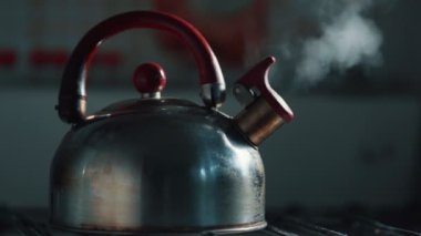 Kaynayan ve ıslık çalan bir çaydanlığın manzarası. Buhar dokusu güzel bir bokeh arka planda. Klasik metal çaydanlık. Sıcak içecekler hazırlanıyor. Yüksek kalite 4k görüntü