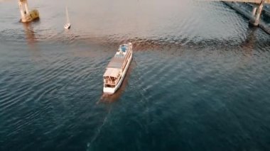 Aerial view of the pedestrian bridge across the Dnieper River.People walk on a pedestrian bridge with bike paths.A pleasure boat passes through the water under the bridge.High quality 4k footage