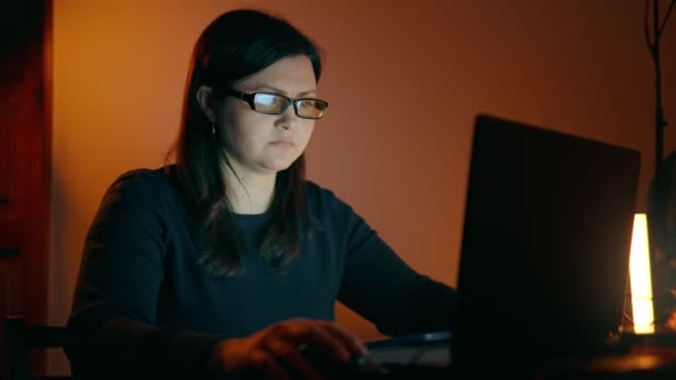 一个年轻的女孩晚上在家里的笔记本电脑上工作 专注于工作的女孩 自由撰稿人在家工作高质量的4K镜头 — 图库视频影像