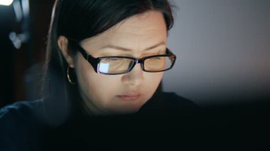 Uzaktan kumandalı bir işçi ev ofisindeki bir dizüstü bilgisayarın başında oturuyor. Evde çalışan odaklanmış bir kadının yakın plan portresi. İnternette çalışıyorum. Serbest çalışıyorum. Yüksek kalite 4k görüntü