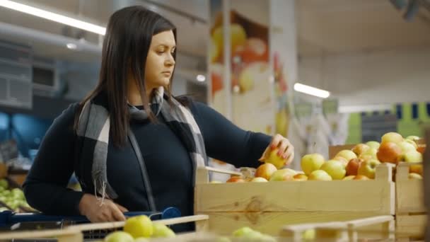 買い物客の女の子はスーパーマーケットの窓に来て 箱から熟したジューシーなリンゴを選択します スーパーマーケットの果物 女性がスーパーで買い物をしている サイドビュー 4K形式の高品質の撮影 — ストック動画