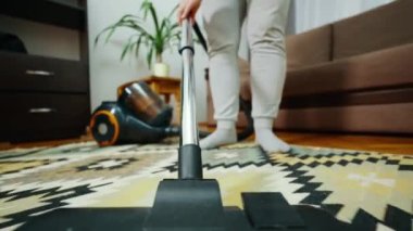 Bir odadaki halının üzerinde çalışan bir elektrik süpürgesinin yakın çekimi. Yerdeki tozları temizliyorum. Alt manzara. Yüksek kalite 4k görüntü