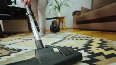 Elektrikli süpürgeyle odayı temizliyorum. Hortumu kapatıyoruz. Elektrik süpürgesi halıyı temizler. Bakış açısından ateş edilmiş. Yüksek kalite 4k görüntü