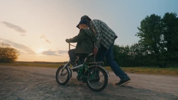 Der Großvater Fährt Den Enkel Des Jungen Bei Sonnenuntergang Mit — Stockvideo