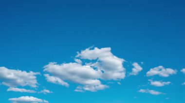 Açık bir günde mavi gökyüzünde beyaz ve karmaşık bulutların görünmesi. Bulutlu zaman dilimi. Güzel beyaz bulutlar. Yüksek kalite 4k görüntü