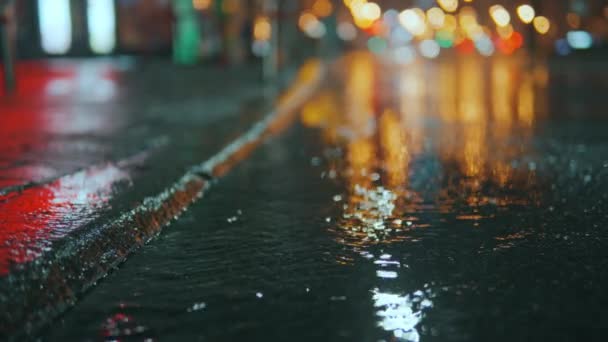 女人穿运动鞋的脚在夜里踏进了一个雨季的水坑 在一个下雨天的黄昏 一个女孩慢吞吞地沿街走着 夜城街灯的光芒 高质量的4K镜头 — 图库视频影像
