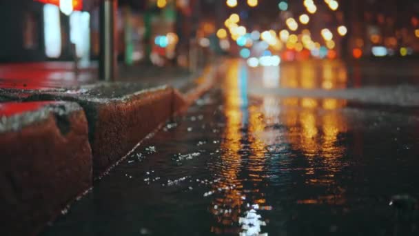 摘要雨夜现代城市 少女走进人行道旁的水坑 湿鞋子 多雨的城市雨滴落在由路灯照明的多色沥青上 高质量的4K镜头 — 图库视频影像
