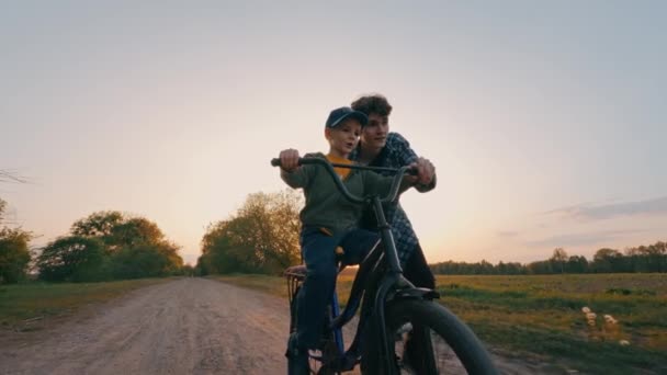 Radosni Bracia Uczą Się Jeździć Rowerze Zachodzie Słońca Starszy Brat — Wideo stockowe