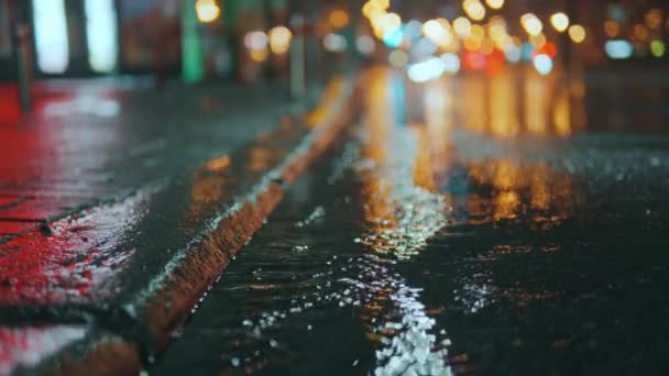 女人的腿在夜城的水坑中走着 街灯和汽车前灯反射在潮湿的路面上 多雨的城市高质量的4K镜头 — 图库视频影像