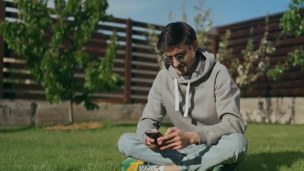 Jeune Homme Lunettes Soleil Avec Téléphone Main Assoit Sur Une — Video