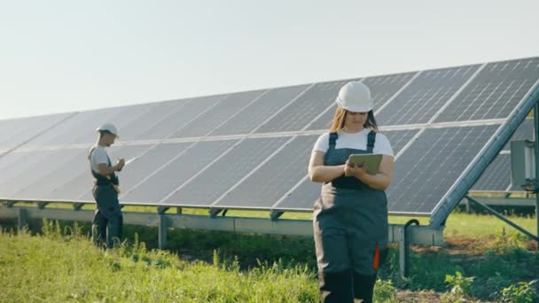 一位女工程师使用设计平板电脑收集有关太阳能电池板的有效信息 太阳能光伏农场 绿色能源 星期三 绿色能源概念 高质量的4K镜头 — 图库视频影像