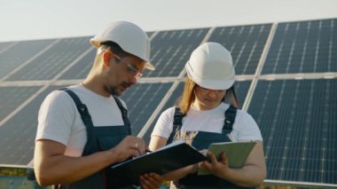 Baş mühendis ve uzman güneş enerjisi santralinin sonuçlarını inceliyor. İş ekibi. Temiz enerji. Endüstri. Fotovoltaik güneş çiftliği. Yeşil enerji.